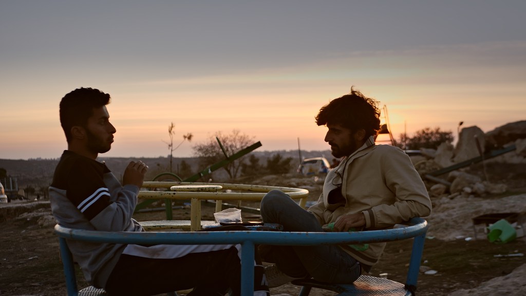 Basel Adra, a Palestinian activist, and Yuval Abraham, an Israeli journalist, sit having a conversation together